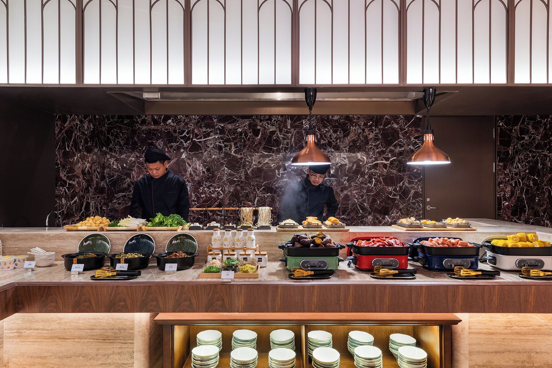 A buffet setup with various food items and cooking stations.