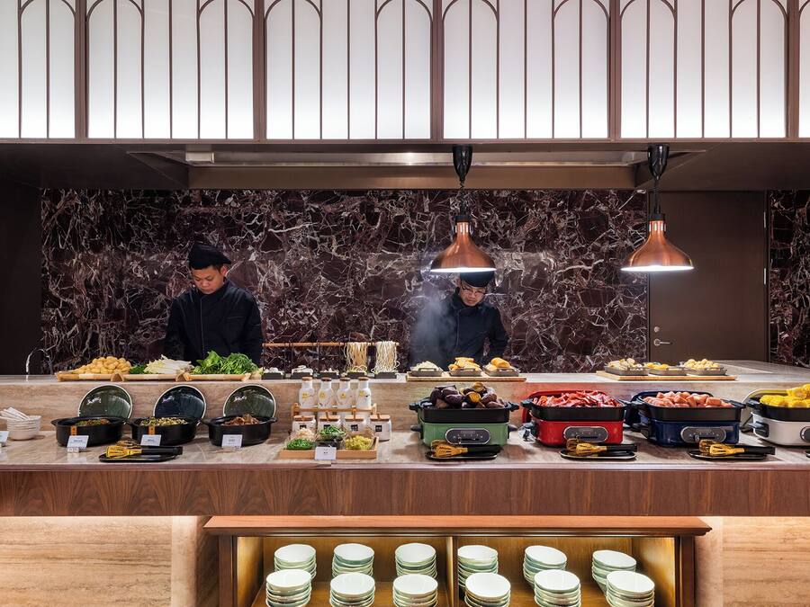 A buffet setup with various food items and cooking stations.