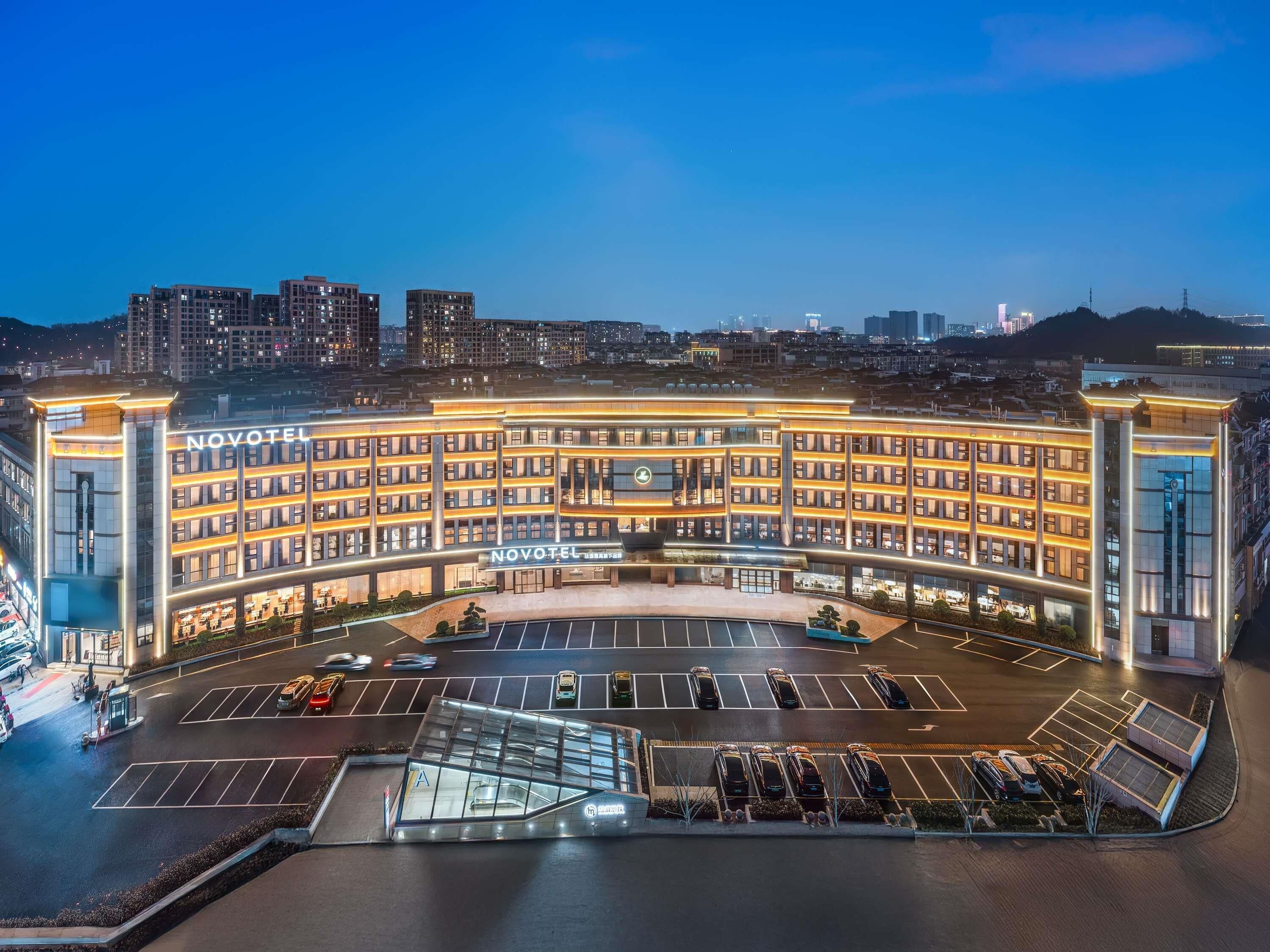 Un hotel de varios pisos con un atrio central y una zona de estacionamiento.