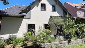 A two-story house with a gabled roof, a front door, and a small porch area.