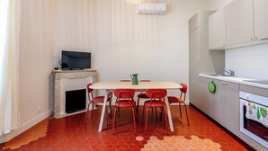 Eine kompakte Küche mit Esstisch, Stühlen, Fernseher und Kamin.