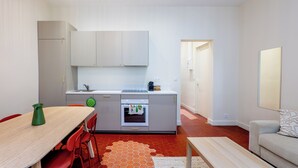 Eine kompakte Küche mit Essbereich, einer Couch und einem kleinen Tisch.