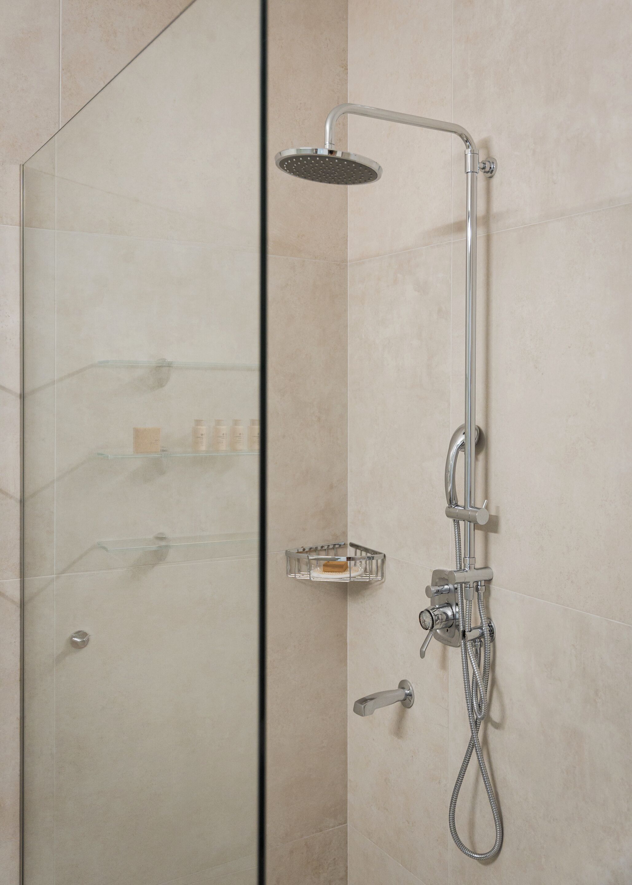 Une douche moderne dotée d’un pommeau de douche à main et d’un robinet mural.