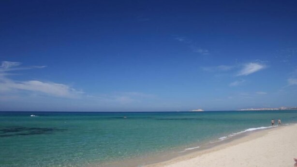 Una playa con agua turquesa cristalina y una orilla arenosa.