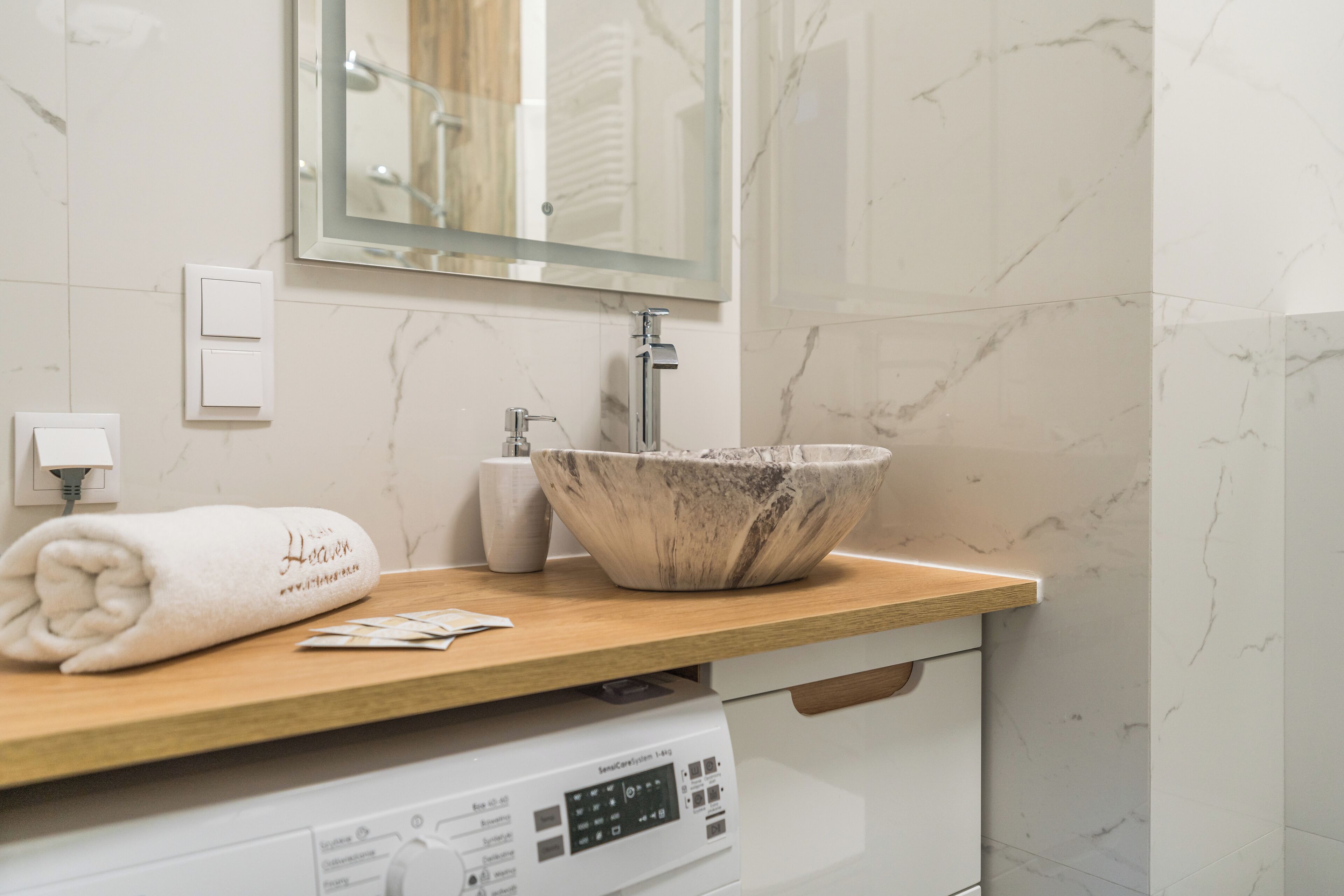 A bathroom with a marble sink, a towel, and a mirror.
