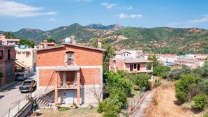 Zona residencial con casas, una carretera y montañas al fondo.