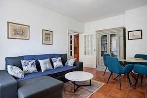 Un salon comprenant un canapé, une table basse et un coin repas avec des chaises et une table.