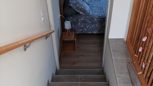 A staircase leading to a bedroom with a bed, bedside table, and a nightstand. - T2 house with small adjoining plot, very nice. (Sète)