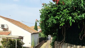 A narrow alleyway with a stone wall on one side and a building with a tiled roof on the other. - T2 house with small adjoining plot, very nice. (Sète)