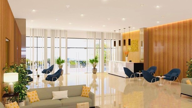 En modern hotellobby med en receptionsdisk, en sittgrupp och stora fönster.