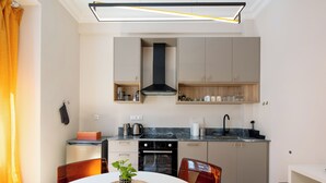 A modern kitchen with a central island, built-in oven, and a microwave. - Spark 2-Bedroom Apartment in Athens (Athens)