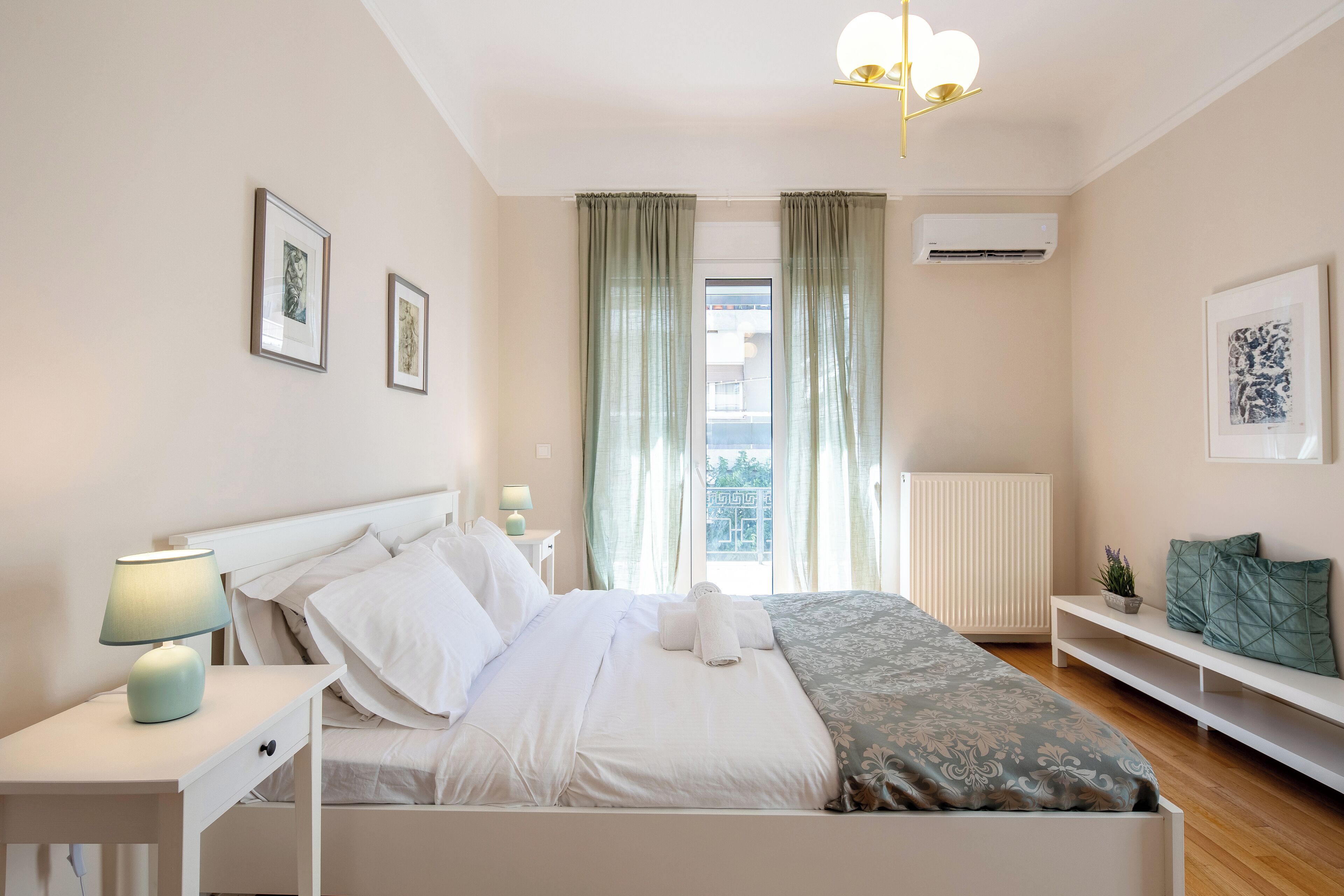 Un dormitorio con cama, mesitas de noche, lámpara, ventana con cortinas y decoración en la pared.