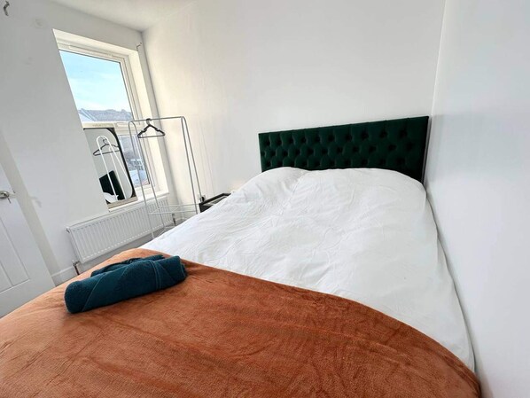 A bedroom with a bed, a window, and a radiator. - Southsea 5-bed Seaside Retreat- Sleeps 11 & Garden (Portsmouth)