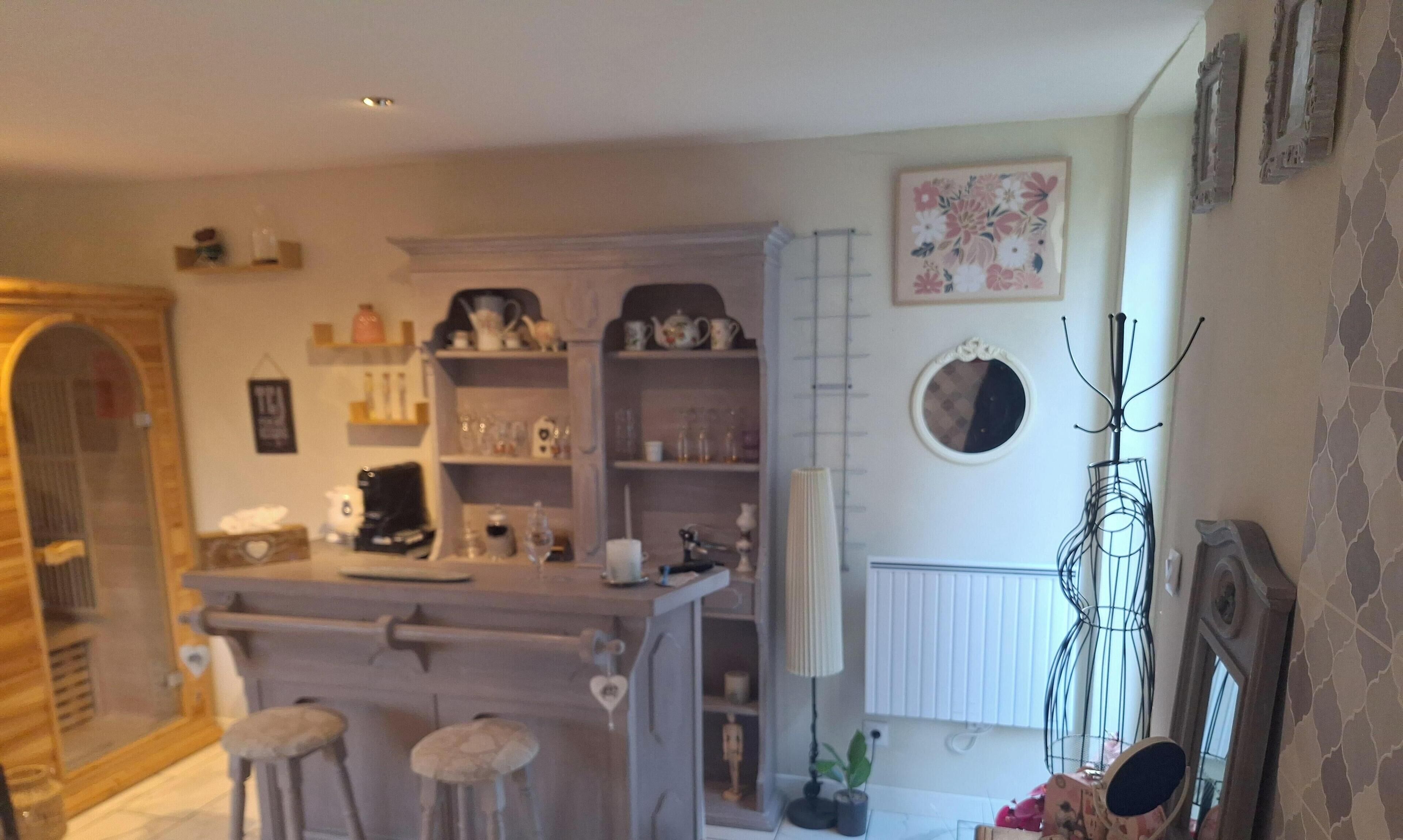 Een gezellige keuken met een centraal kookeiland, barstoelen en een decoratieve spiegel.