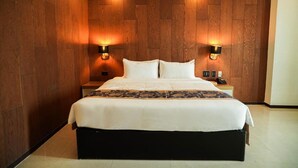 A large bed with a dark headboard, two bedside tables, and wall-mounted lights. - Dancenter Luxury Retreat Angeles City (Angeles City)