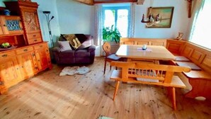 A cozy room with a wooden bench, a sofa, and a dining table.