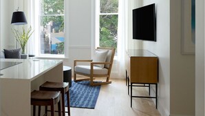 Una cucina moderna con zona bar, ampie finestre e una TV a schermo piatto.