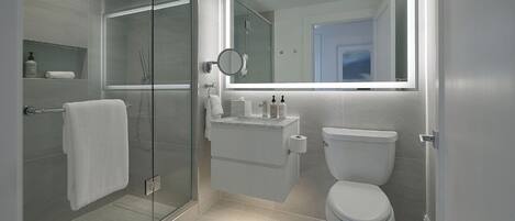 A modern bathroom with a glass-enclosed shower, a toilet, and a vanity with a mirror.