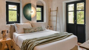 Une chambre à coucher avec un lit, une table de chevet, une lampe, une fenêtre et une porte.