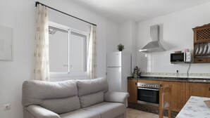 Une petite cuisine équipée d’un four à micro-ondes, d’un four et d’un réfrigérateur.