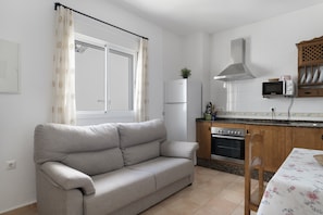 A kitchenette with a microwave, oven, and refrigerator.