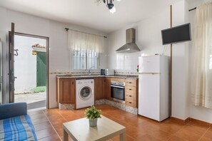 Une cuisine compacte équipée d’un lave-linge, d’un four et d’un four à micro-ondes.