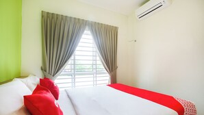 A hotel room with a bed, a window with curtains, and an air conditioning unit. - Junction Hostel Poblacion Makati Avenue (Makati)