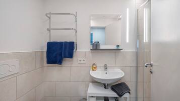 Ein modernes Badezimmer mit Waschbecken, Spiegel und Handtuchhalter.