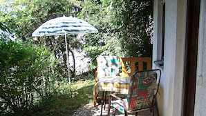 A patio with a table and chairs, an umbrella, and a view of greenery. - Studio 'Unterschütz' with Mountain View, Private Terrace and Wi-Fi (Ettenheim)
