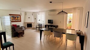 A spacious living area with a fireplace, dining table, and comfortable seating. - Casa Belavista near Lisbon (Palmela)