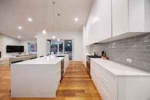 Una cocina moderna con armarios blancos, una isla central y un salpicadero de azulejos.