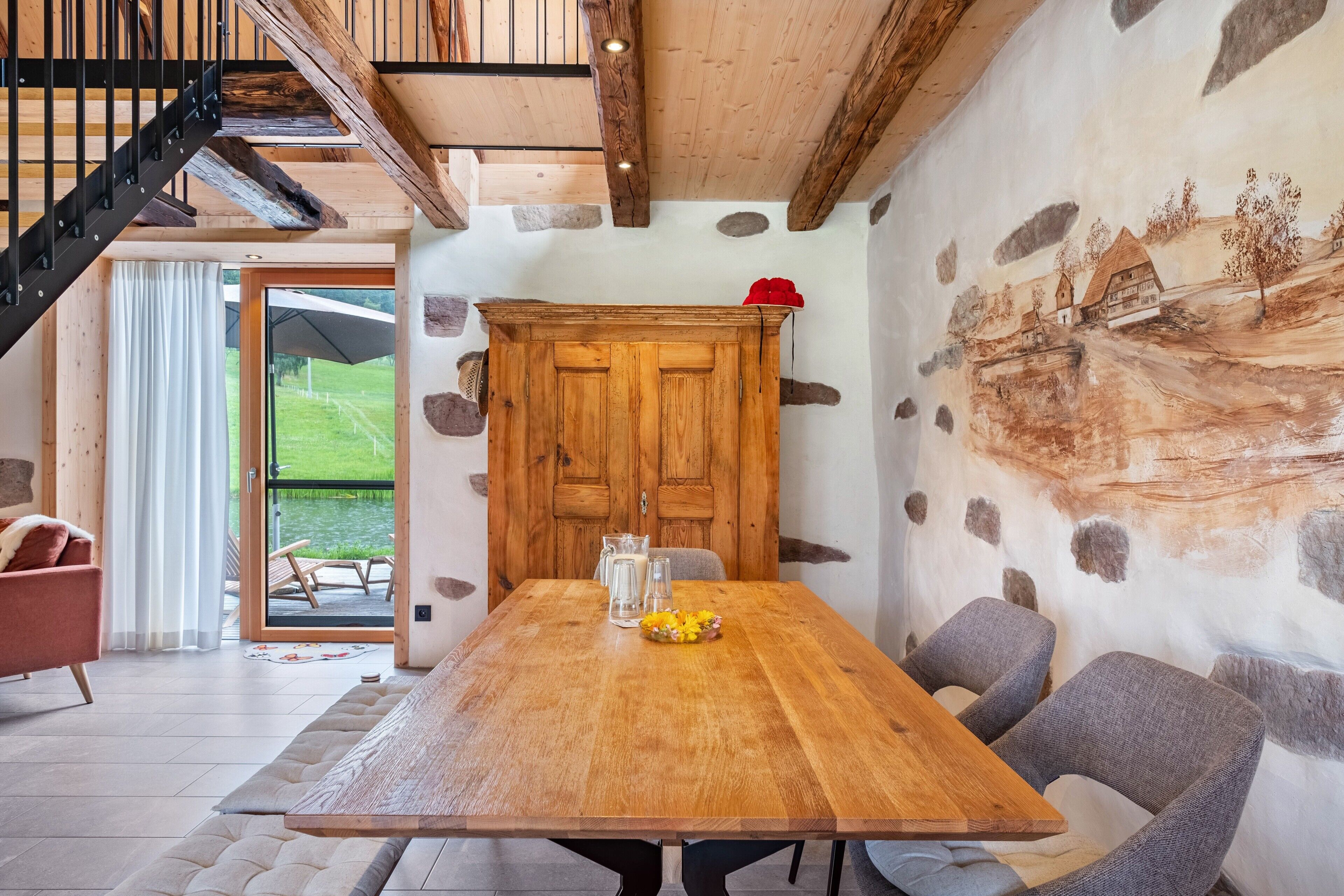 Un espace repas avec une table en bois, des chaises et une vue sur l’extérieur.