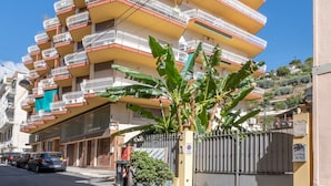 A multi-story building with balconies, a gated entrance, and a street in front. - Penthouse Seaview by Wonderful Italy (Sanremo)