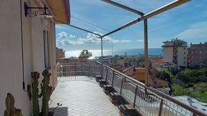 A balcony with tiled flooring, potted cacti, and a metal railing. - Penthouse Seaview by Wonderful Italy (Sanremo)