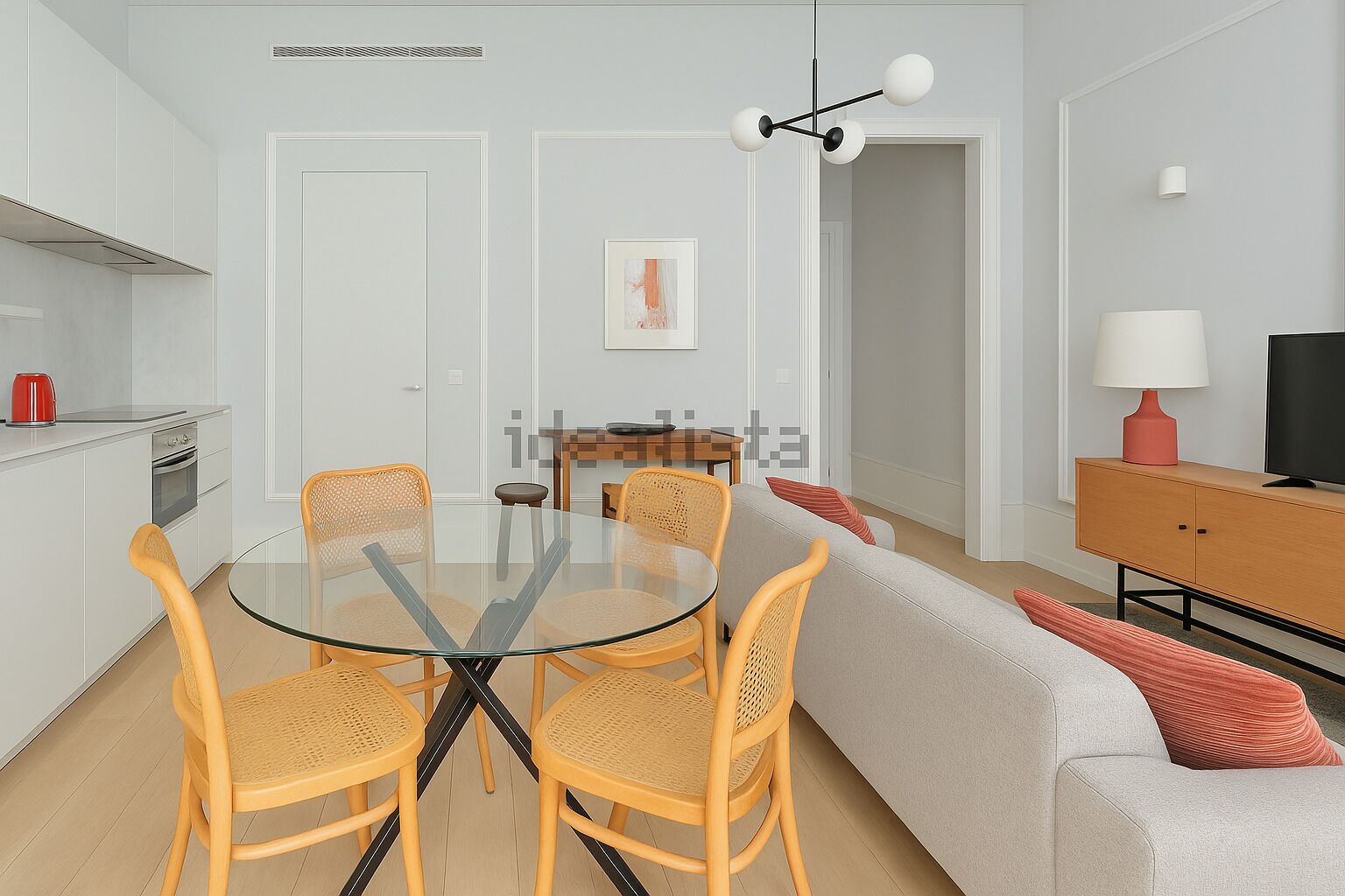 A modern kitchen with white cabinets, a red kettle, and a dining area with a glass table and wicker chairs.