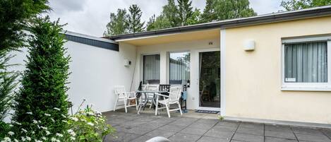 Un edificio residencial con un patio, una mesa de comedor y sillas.