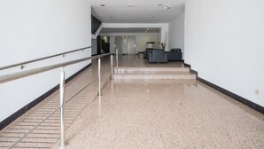 A clean, modern lobby with a marble floor, a staircase, and a reception area with a desk and chairs. - Apartment in Las Palmas Near Las Canteras Beach (Las Palmas de Gran Canaria)