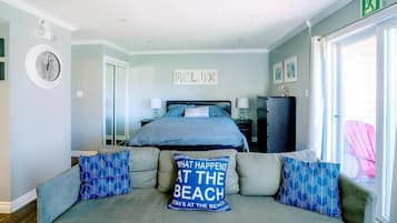 A bedroom with a bed, a sofa, a clock, and a sign on the wall.