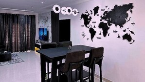 Un soggiorno moderno con zona pranzo, una grande mappa del mondo appesa al muro e un televisore.