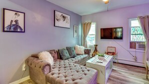 A living room with a tufted sofa, a coffee table, and artwork on the walls. - 3 Mi to Dtwn Newark: Eclectic & Walkable Apt! (Newark)