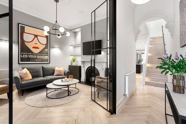 Een moderne woonkamer met een bank, salontafel en een open haard.