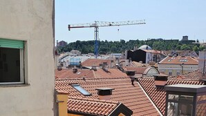 A view of a residential area with terracotta-tiled roofs, a construction crane in the background, and a clear sky. - Orienty Home Pentacoro (Trieste)