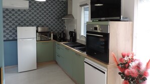 Una cucina moderna dotata di frigorifero, microonde, macchina del caffè, forno e lavastoviglie.