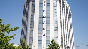 A tall building with the word "ARMADA" vertically displayed on its facade.