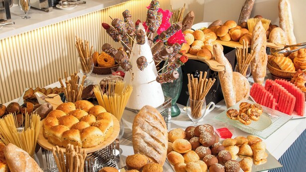 A buffet with various baked goods and pastries.