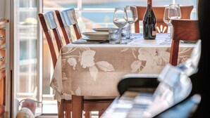 A table set with a wine bottle, glasses, and a plate, overlooking a scenic view.