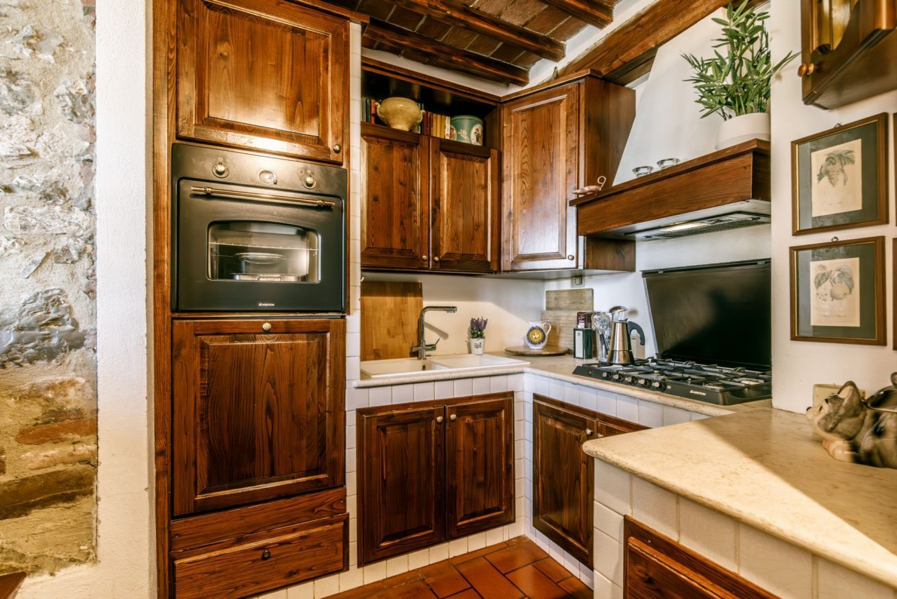 Una cocina con armarios de madera, estufa y lavabo.
