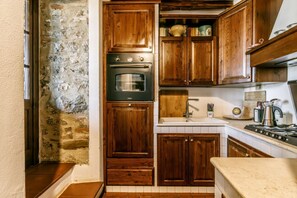 A kitchen with wooden cabinets, a built-in oven, a sink, and a stove.