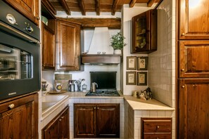 A kitchen with wooden cabinets, a stove, and a sink.