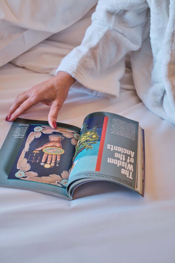 A person reading a book on a bed.